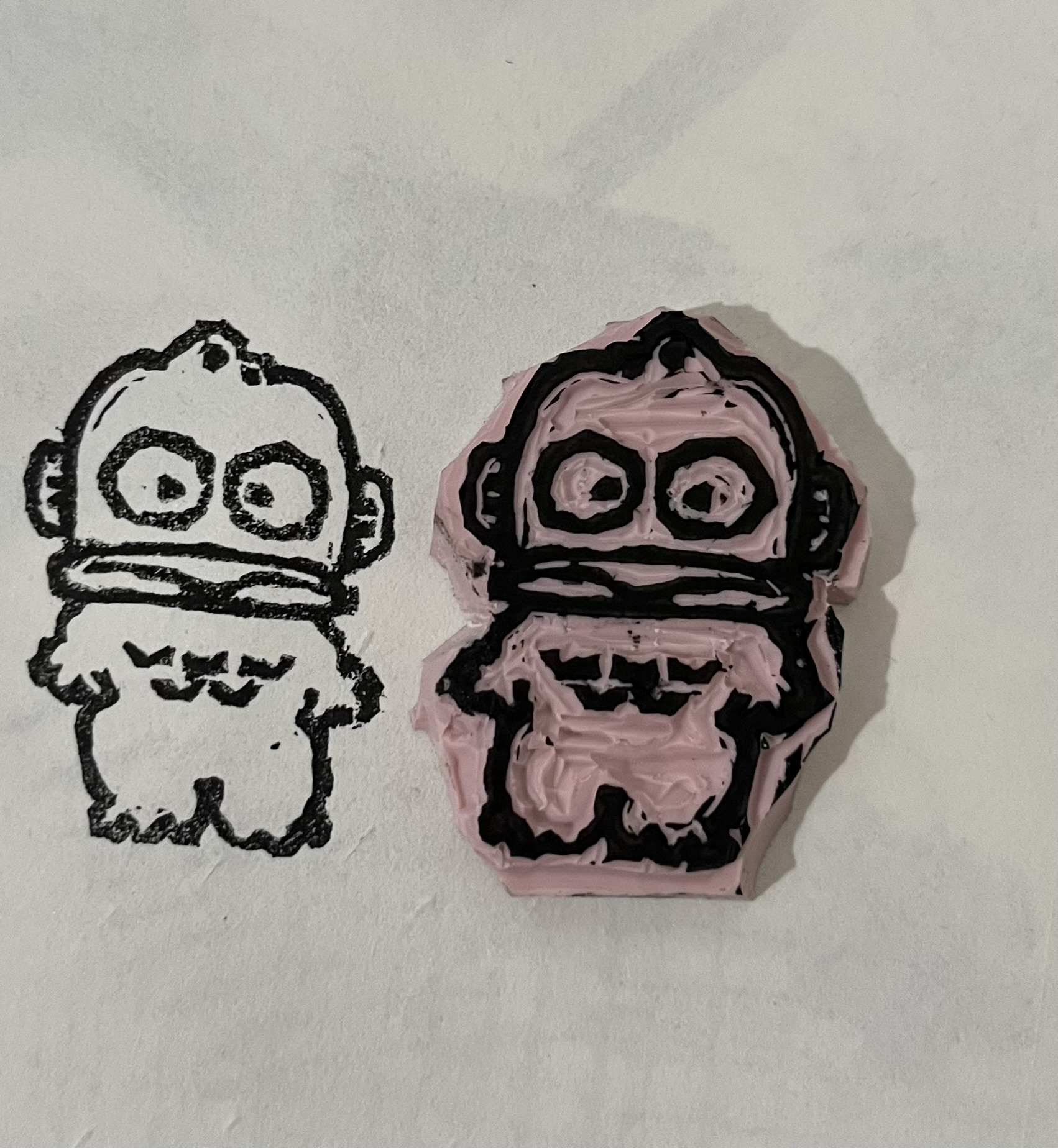 image of a rubber stamp with the image of hangyodon
carved into it, on a piece of paper stamped using the rubber stamp